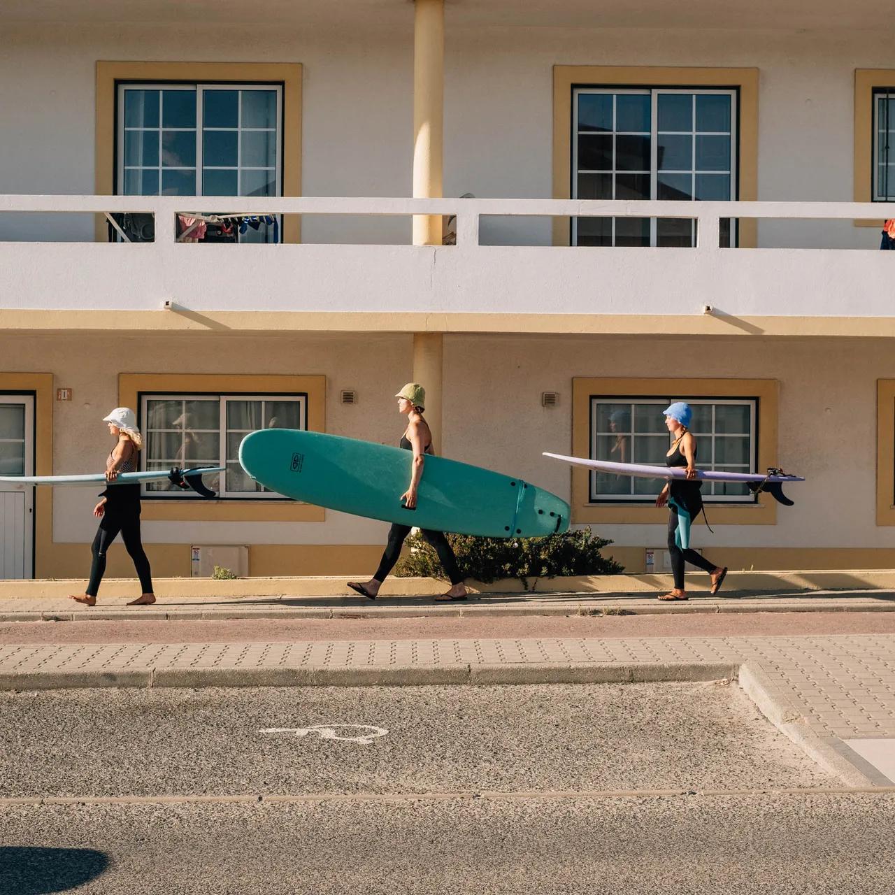Tre surfare på väg till stranden i Baleal