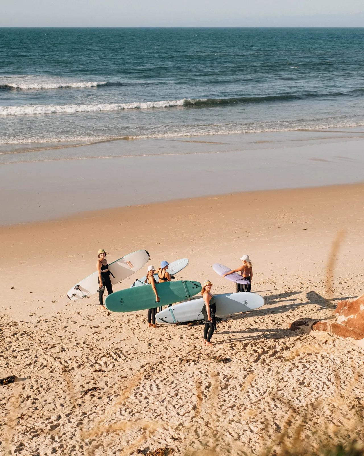 En grupp som står på stranden med surfbrädor