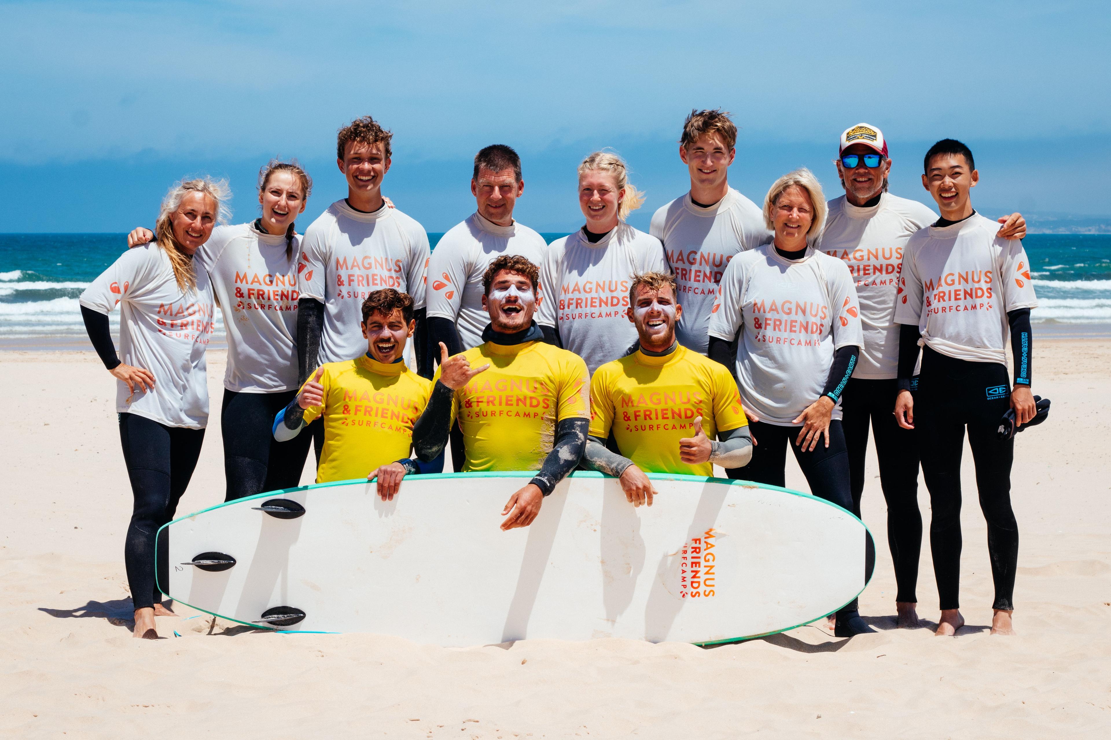 Ett gäng glada surfare i blandade åldrar på Magnus & friends tillsammans med våra surfinstruktörer