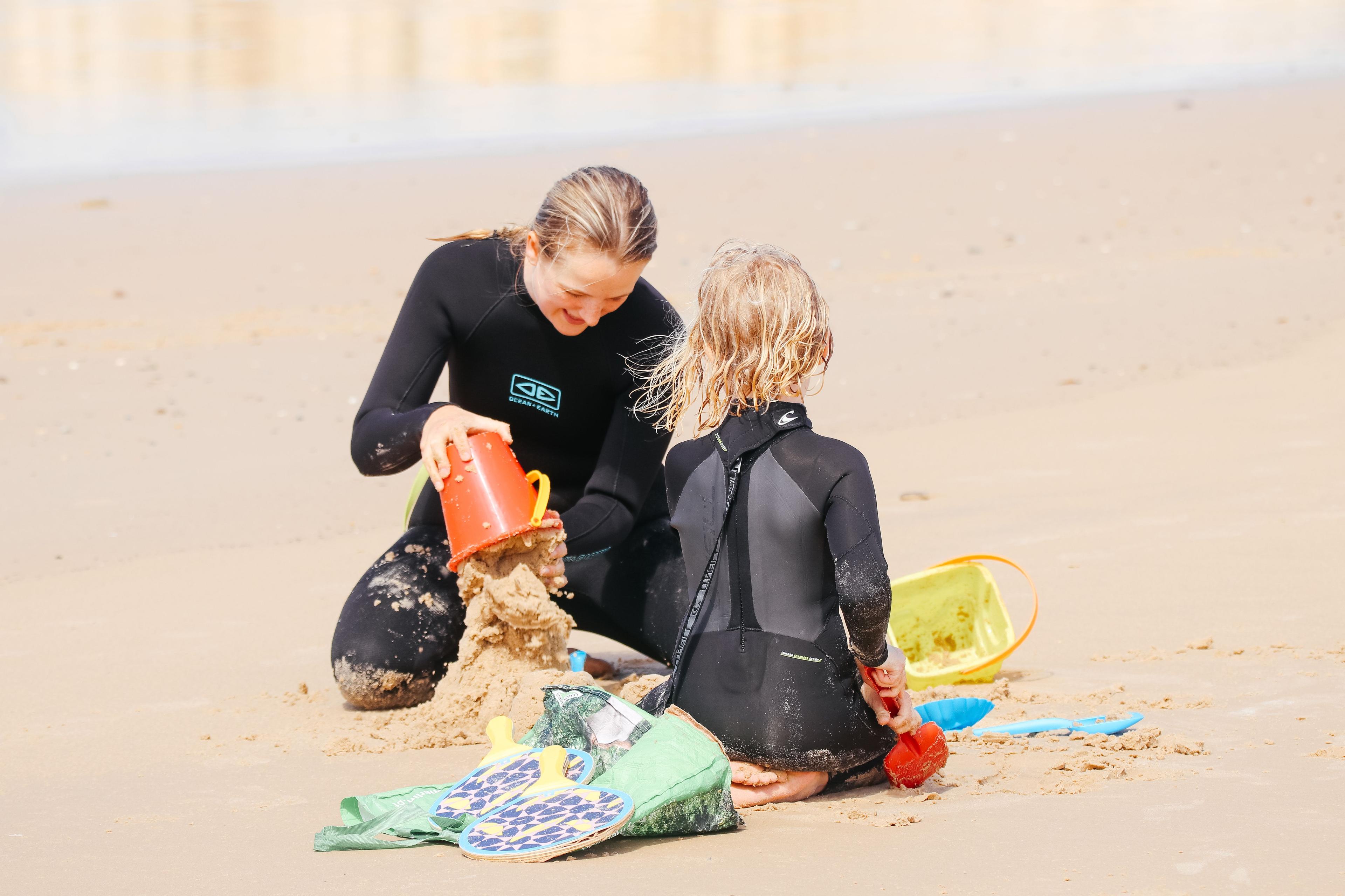 Surfassistent Emma leker med ett barn på stranden