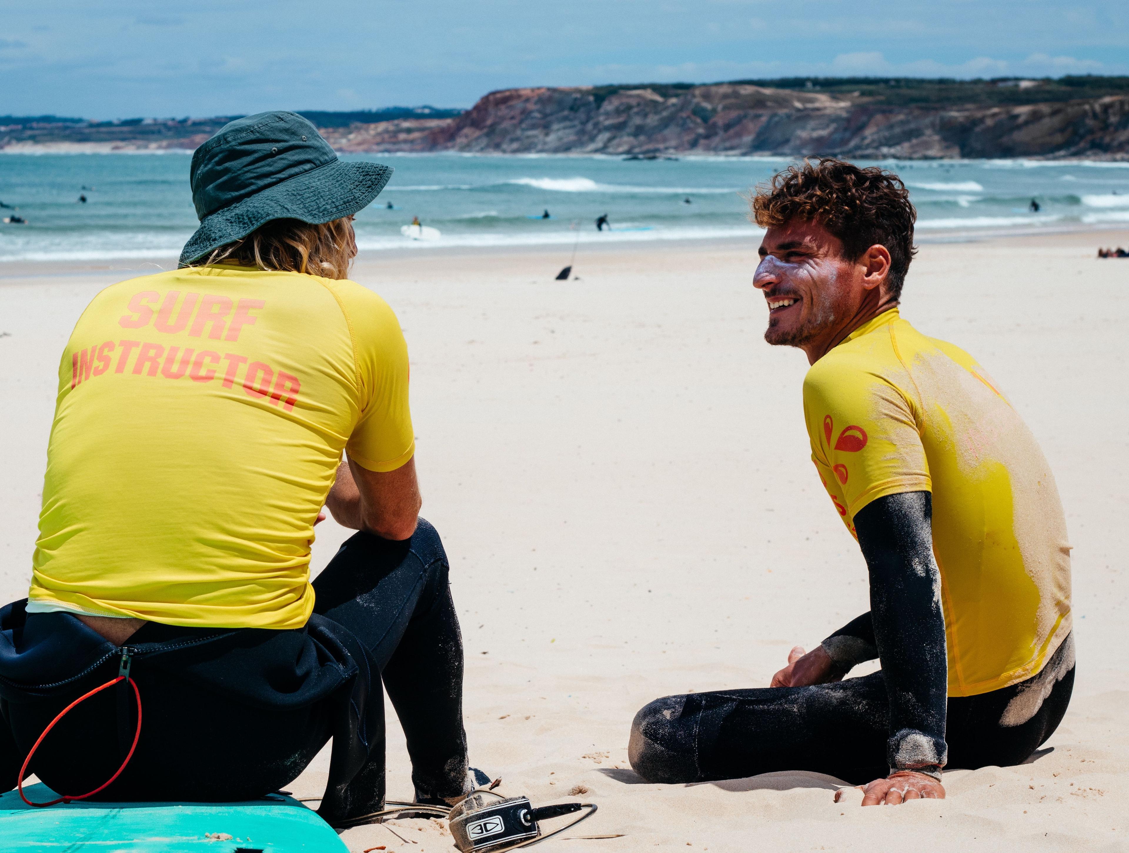 Surfinstruktörerna Rodrigo och Fedrico sitter på stranden 