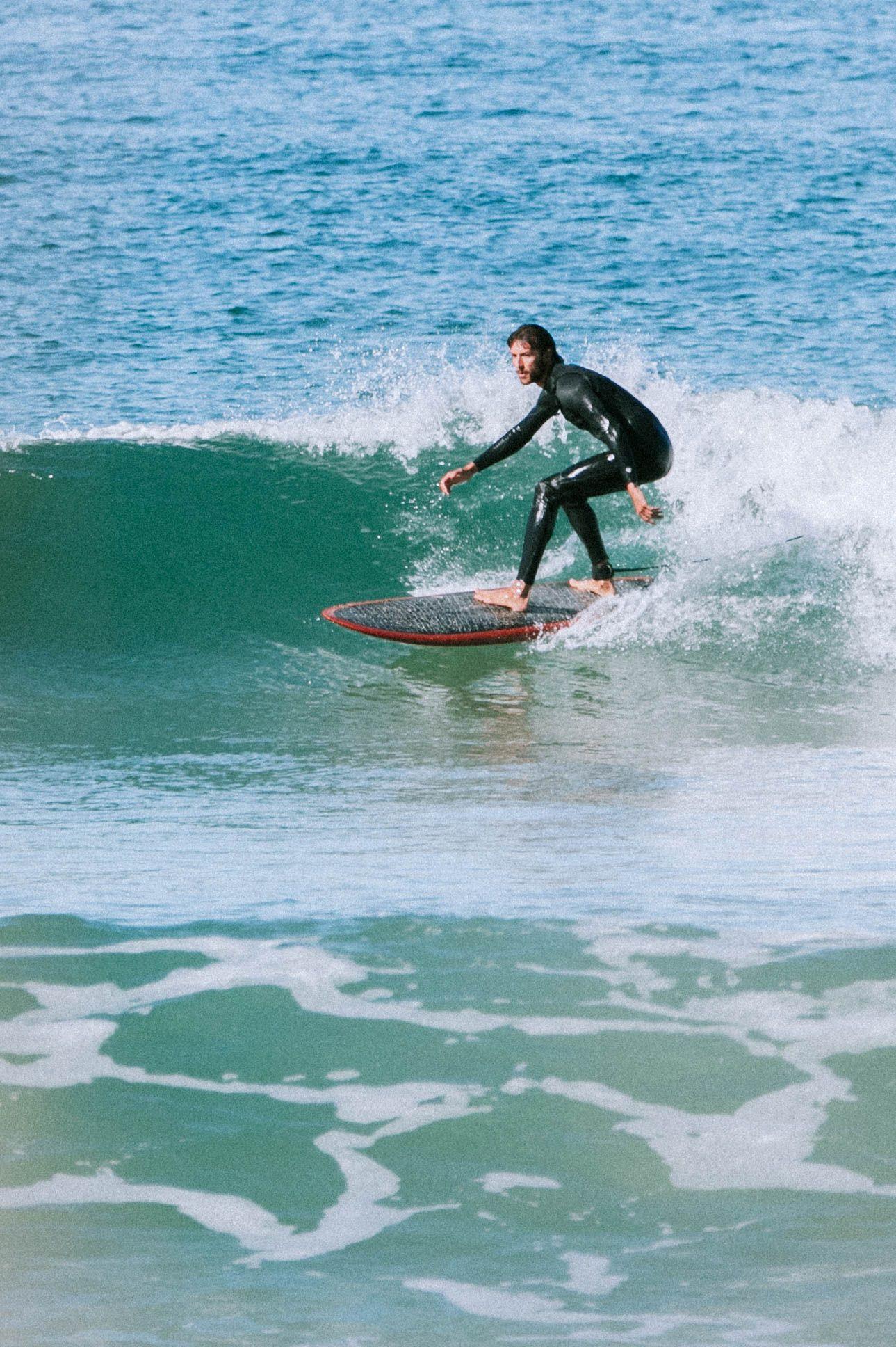 Surfare på grön våg i Baleal, Portugal