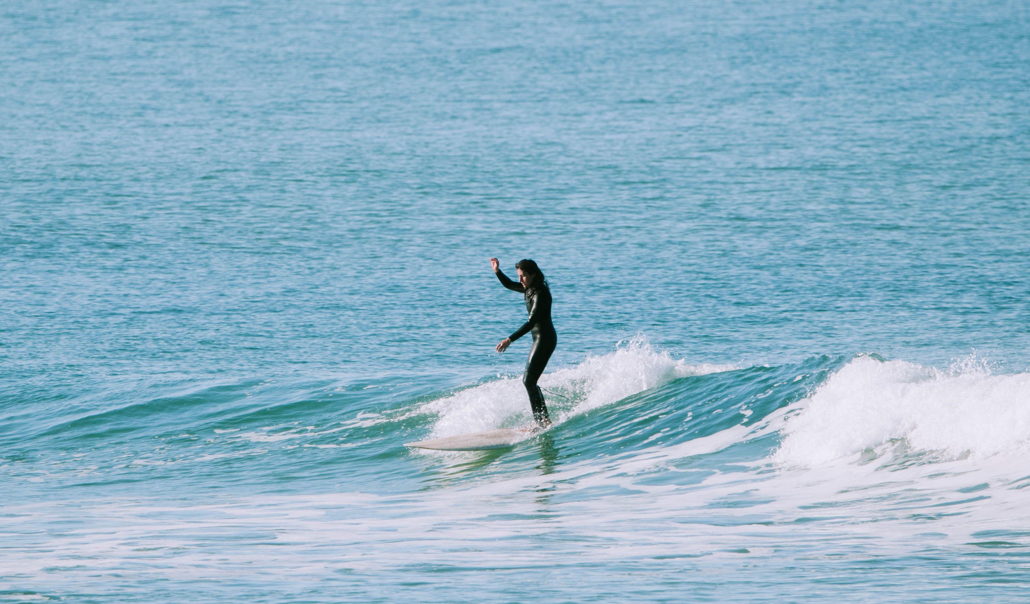 En surfare på en våg i Baleal, Portugal