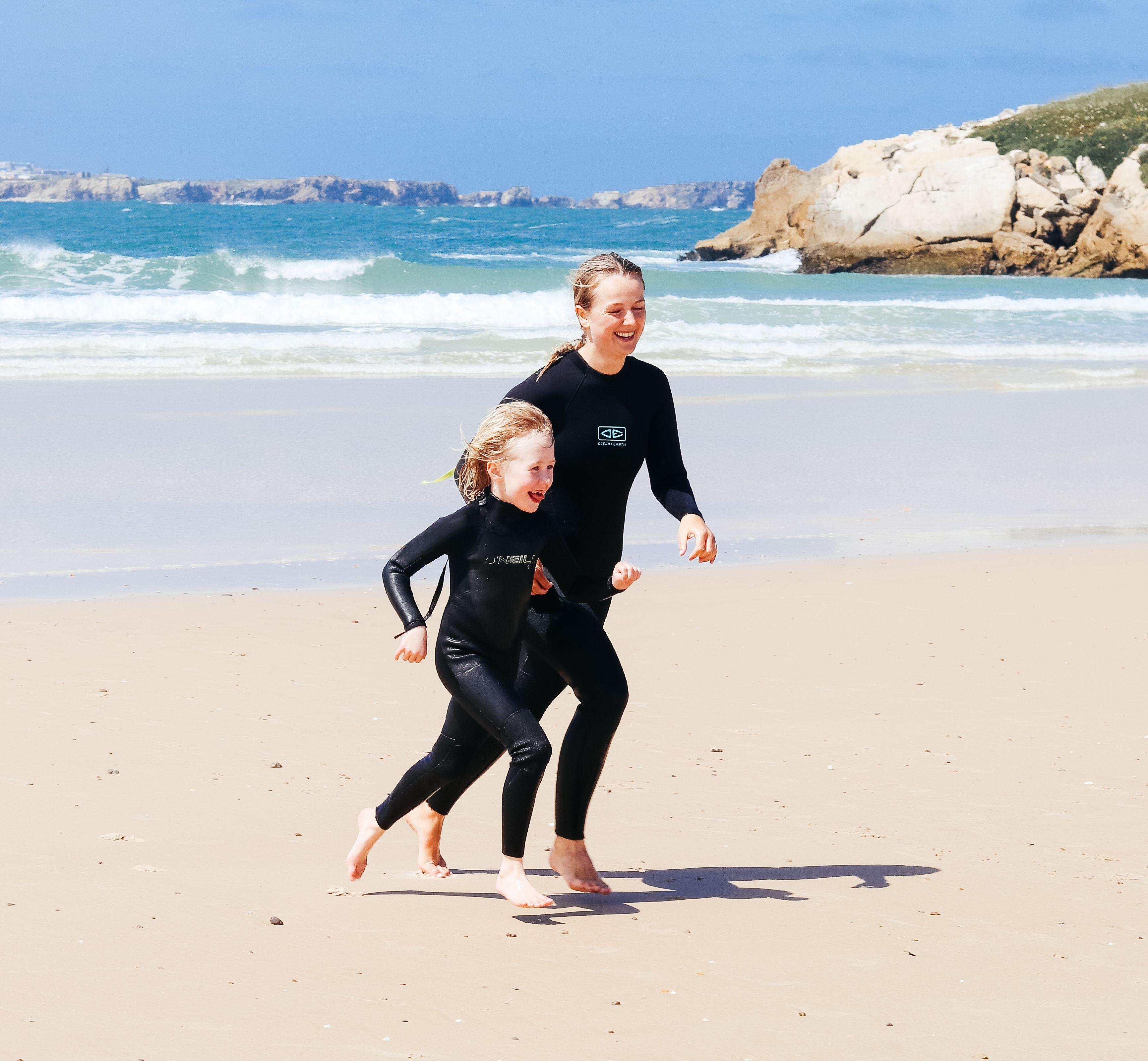 Surfassistent Emma leker med ett barn på stranden