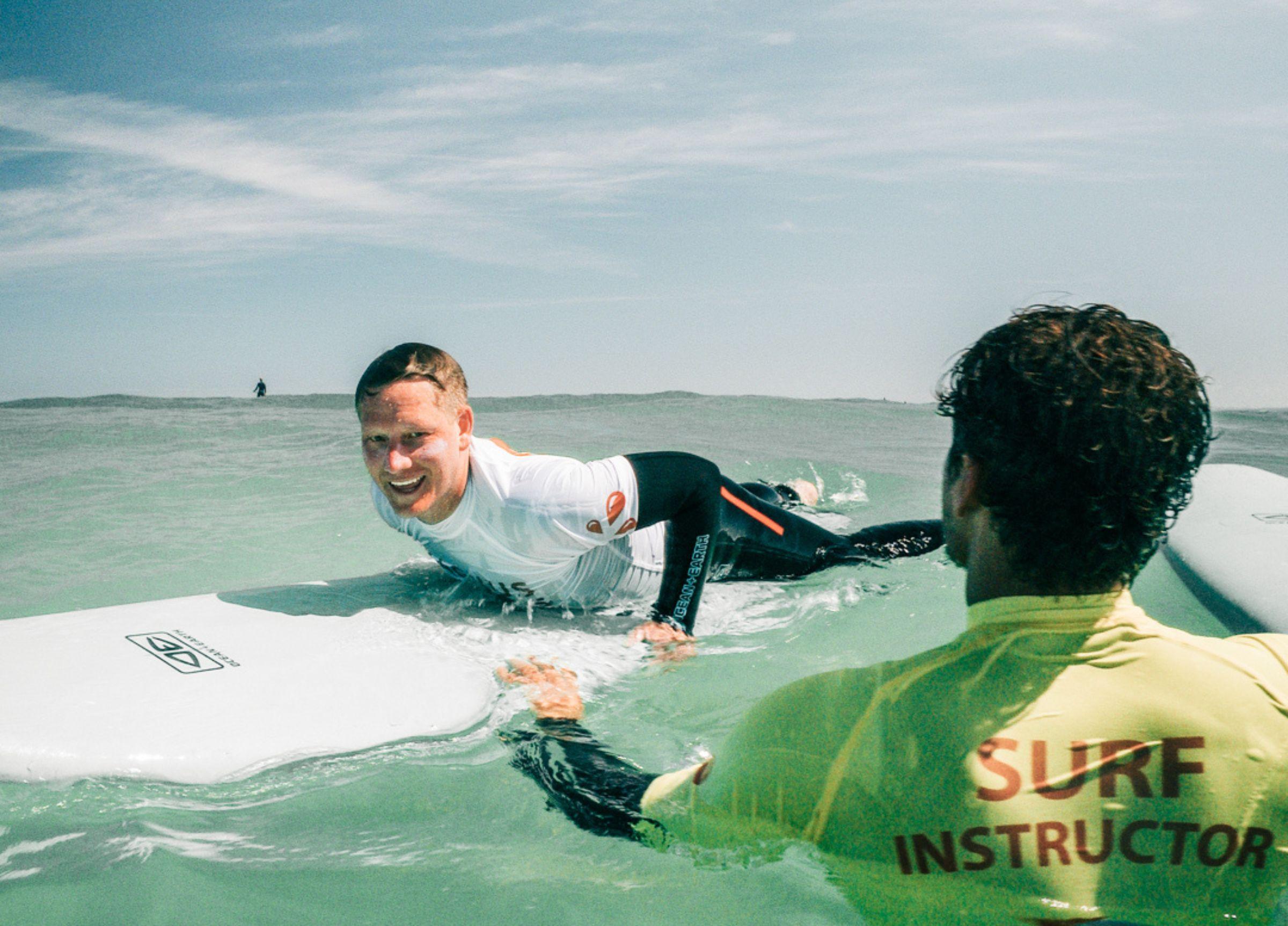 Surflektion med Aldrig Ensam – Charlie får hjälp av instruktör i vattnet i Baleal