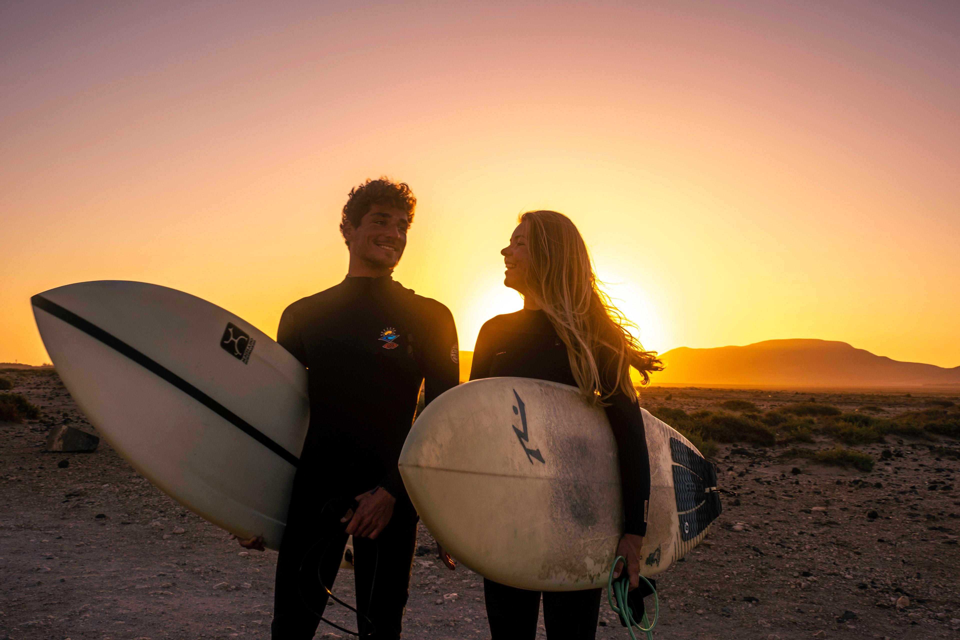 2 glada surfare i solnedgången på Fuerteventura