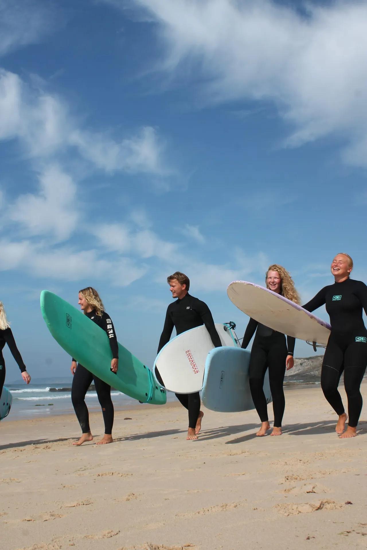 Surfare som går på stranden