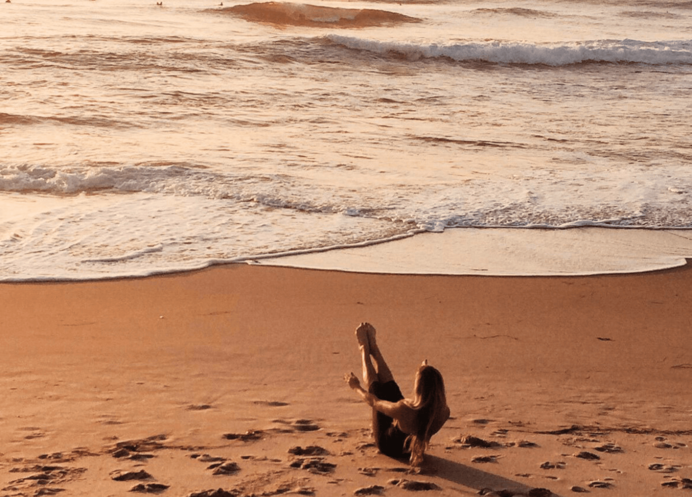 Tjej som gör yoga och meditation på stranden i solnedgången