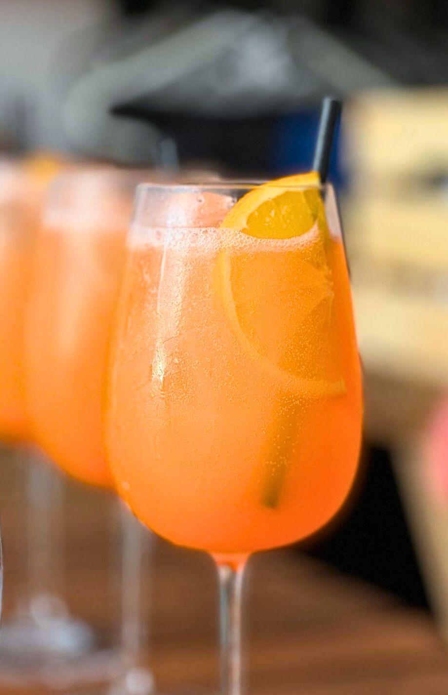 Goda Aperol Spritz drinkar i glas med sugrör